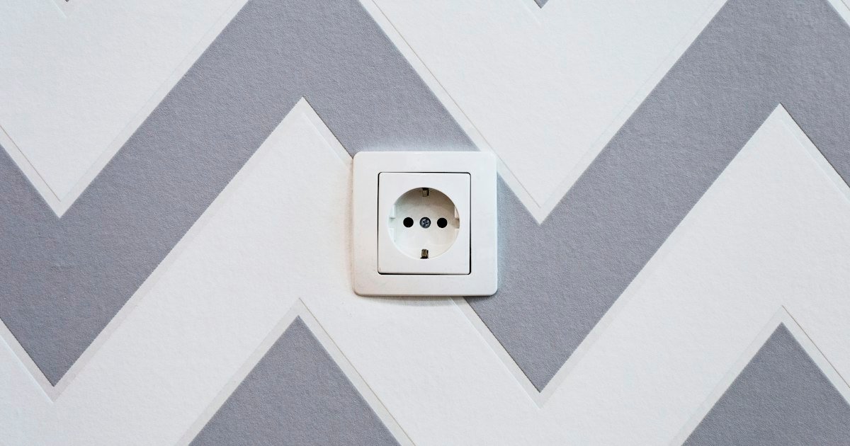 Power strip on a wall, illustrating safe electrical load considerations