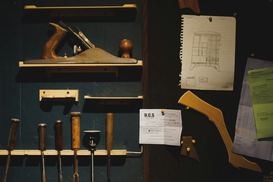 Woodworking tools and blueprints organized on a dark workshop wall